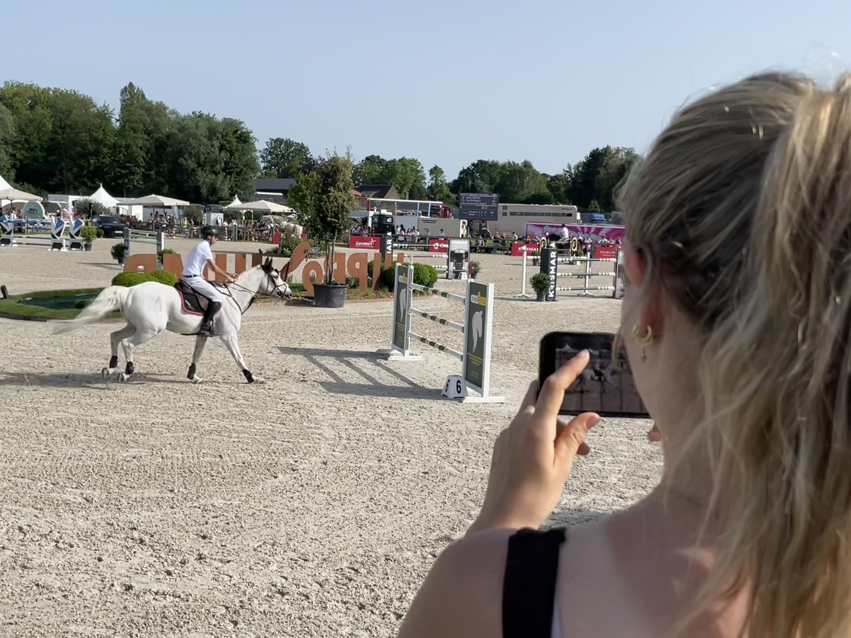Filming a show jumping round on a smartphone at the ring